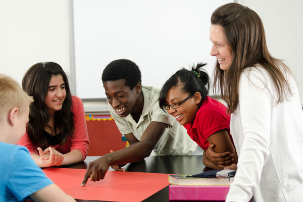 Teacher with middle school students working in a circle